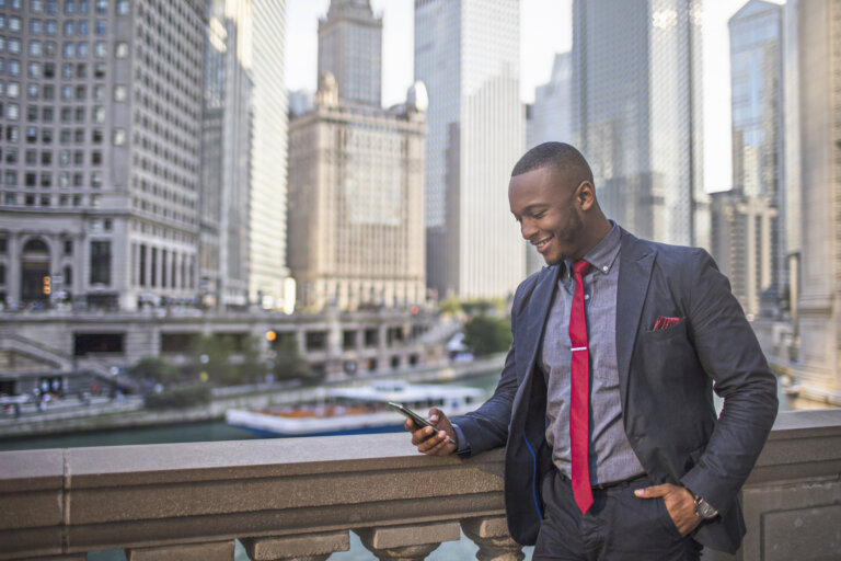 Businessman checking his mobile phone in downtown Chicago.